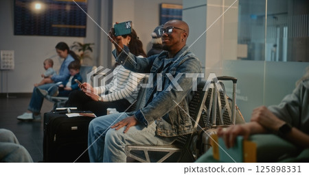 Man Talking by Video Chat, Filming Video Content Using Smartphone in Airline Hub Lounge Man Talking by Video Chat, Filming Video Content Using Smartphone in Airline Hub Lounge 125898331