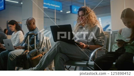 Crowded Airport Terminal: Woman Working on Laptop, Having Online Video Call 125898452