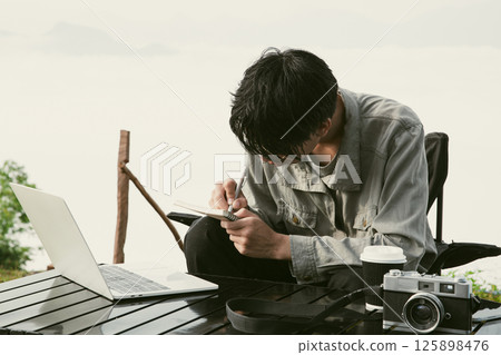 Young business man working computer on peak hill. Hiker online shopping on laptop at sunset, sunrise on top mountain, freelance person remote work with digital tablet. travel vacation holiday concept Young business man working computer on peak hill. Hiker online shopping on laptop at sunset, sunrise on top mountain, freelance person remote work with digital tablet. travel vacation holiday concept 125898476
