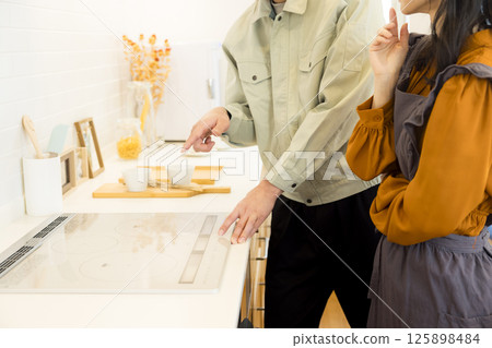 Handing over a house: A man in work clothes doing after-maintenance Handing over a house: A man in work clothes doing after-maintenance 125898484
