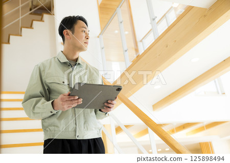 Handing over a house: A man in work clothes doing after-maintenance 125898494