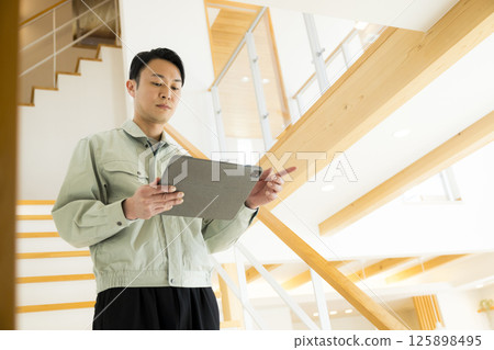 Handing over a house: A man in work clothes doing after-maintenance 125898495