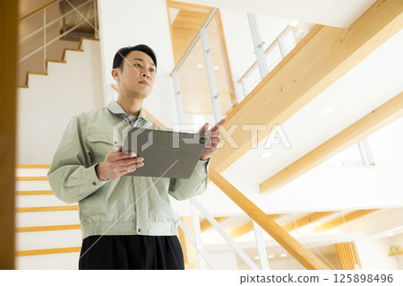 房屋交接:一名身著工作服的男子正在進行後期維護 房屋交接:一名身著工作服的男子正在進行後期維護 125898496