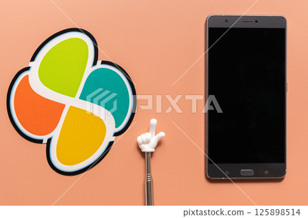 Flat lay of elderly mark, smartphone and pointing stick on orange background 125898514