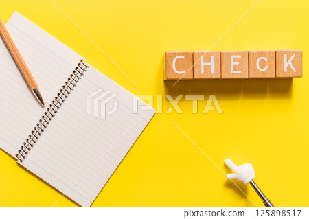 黃色背景上 CHECK 字母塊、筆記本和指點桿的圖像 黃色背景上 CHECK 字母塊、筆記本和指點桿的圖像 125898517