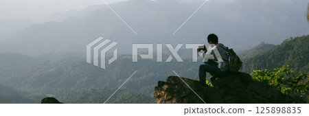 Man traveler with backpack hiking outdoor travel lifestyle and adventure concept. join of tourist for green mountain tour beauty of nature and expansive sky people of tourism. banner with copy space Man traveler with backpack hiking outdoor travel lifestyle and adventure concept. join of tourist for green mountain tour beauty of nature and expansive sky people of tourism. banner with copy space 125898835