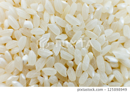 Close-up macro shot of white polished rice in shallow depth of field. Macro raw grain in soft focus Close-up macro shot of white polished rice in shallow depth of field. Macro raw grain in soft focus 125898949