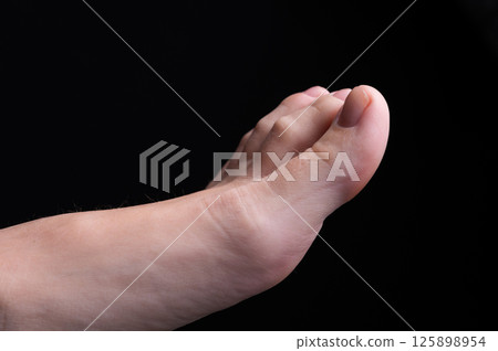 Barefoot feet, on black background. Close-up shot of healthy beautiful female feet. Health and beauty concept. Top view of human foot with neutral manicure or pedicure Barefoot feet, on black background. Close-up shot of healthy beautiful female feet. Health and beauty concept. Top view of human foot with neutral manicure or pedicure 125898954