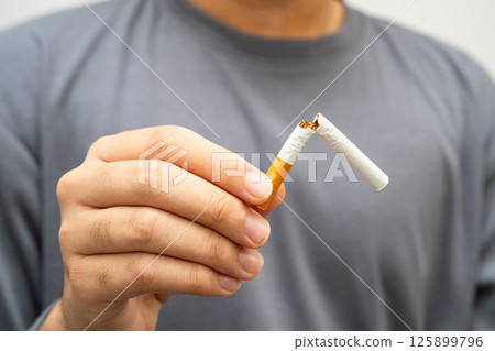 Quit smoking, Asian teenage man breaking destroy cigarette in hand. 125899796