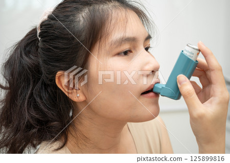 Asian woman use Asthma and chronic obstructive pulmonary disease COPD, Asian young man using metered dose inhaler MDI. Asian woman use Asthma and chronic obstructive pulmonary disease COPD, Asian young man using metered dose inhaler MDI. 125899816