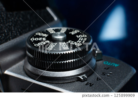 Shutter button on a retro film camera close-up. Modern digital camera made in retro style, close-up of the button that adjusts the shutter speed 125899909
