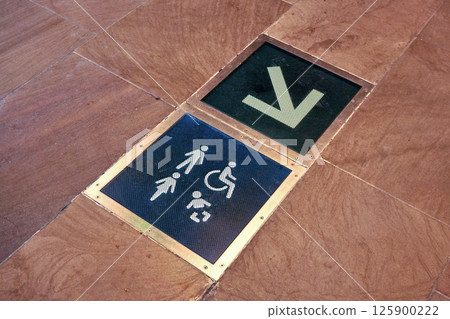 Toilets and baby changing room sign with arrow symbol on the floor of shopping mall Toilets and baby changing room sign with arrow symbol on the floor of shopping mall 125900222