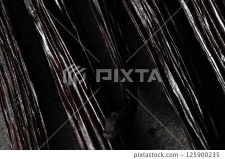 Vanilla beans on dark gray board - abstract close up macro detail with shallow depth of field Vanilla beans on dark gray board - abstract close up macro detail with shallow depth of field 125900235