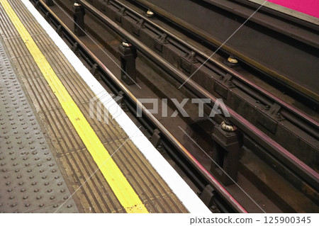 Detail on dirty rails near platform in London underground tube station Detail on dirty rails near platform in London underground tube station 125900345