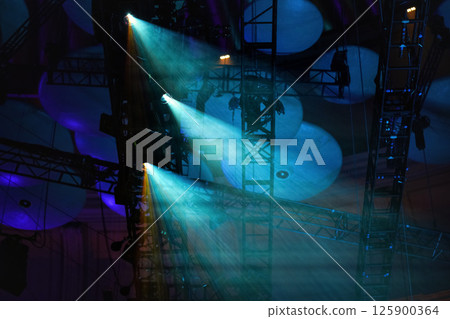 Blue reflector lights shining through smoke on theatre roof before performance 125900364