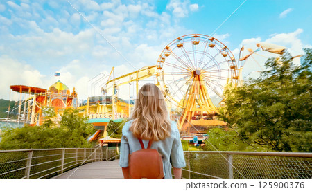 一位背著背包獨自穿過遊樂園的女士的背影，生成 AI_wide 125900376