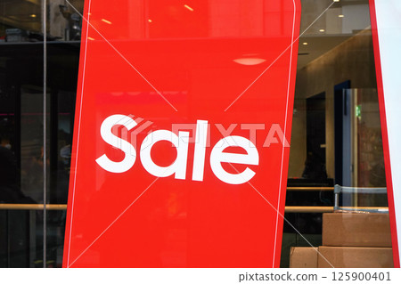 Red poster with word SALE on a glass store or shop window Red poster with word SALE on a glass store or shop window 125900401
