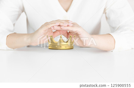 Protective Hands Shielding Golden Crown Representing Leadership and Success 125900555