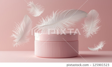A soft pink product container sits on a pink background, surrounded by floating white feathers.  125901523