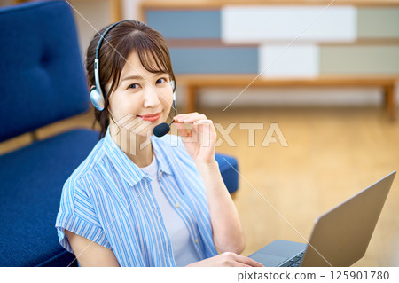 Operator during telework to chat at home using a personal computer 125901780