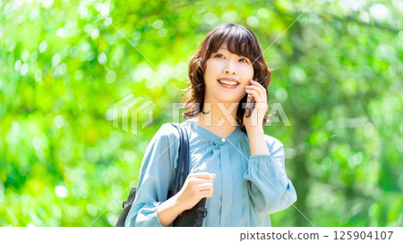 微笑的女人/女商人在智慧型手機上交談 125904107