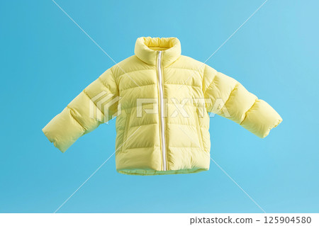 A vibrant yellow winter jacket showcased on a vivid blue background, symbolizing style and warmth. Perfect for representing cold-weather apparel in minimalistic setups. Cleaning service 125904580