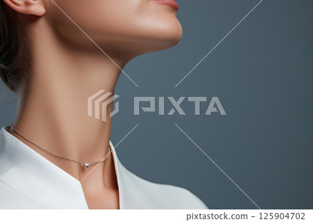 A close-up image of a woman wearing a simple yet elegant necklace, highlighting sophistication and minimalist jewelry design often seen in fashion and luxury accessories. 125904702