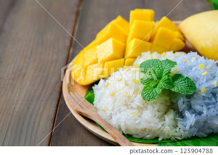 Ripe Mango Sticky Rice is a classic Thai dessert that combines the natural sweetness of ripe mangoes with rich, creamy coconut-infused sticky rice 125904788