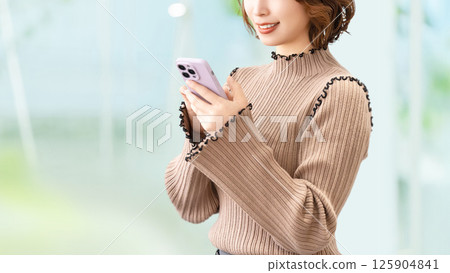 Smiling woman/businesswoman using a smartphone Smiling woman/businesswoman using a smartphone 125904841