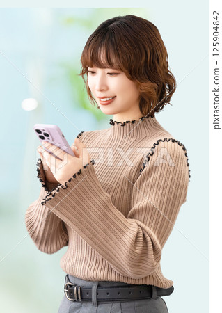 Smiling woman/businesswoman using a smartphone 125904842