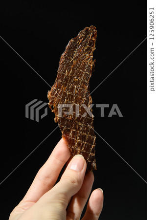 Chicken meat, jerky, slice in hand. 125906251
