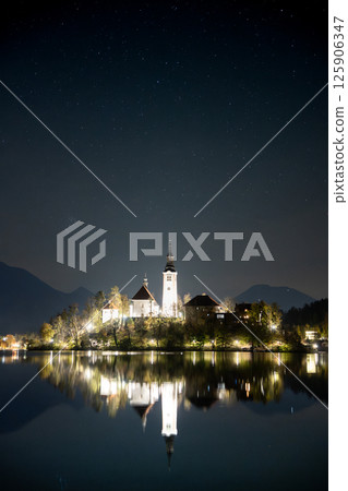 Vertical shot of night sky and stars above small church in the middle of a lake, Bled, Slovenia 125906347