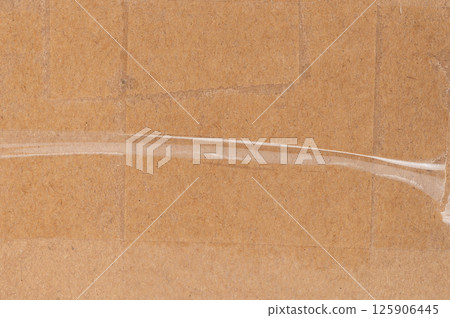 Clear tape applied to cardboard for packaging in shipping facility Clear tape applied to cardboard for packaging in shipping facility 125906445