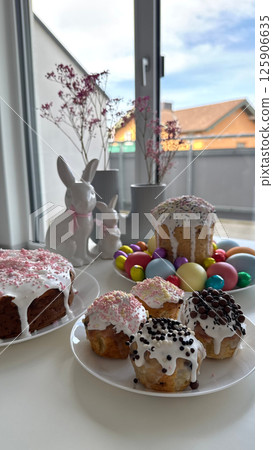 Festive baked goods displayed on a table with colorful decorations and flowers  125906635