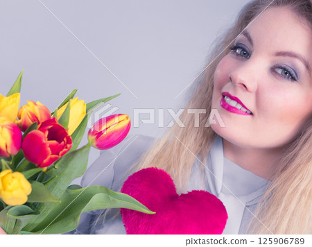 Woman holds tulips and red heart 125906789