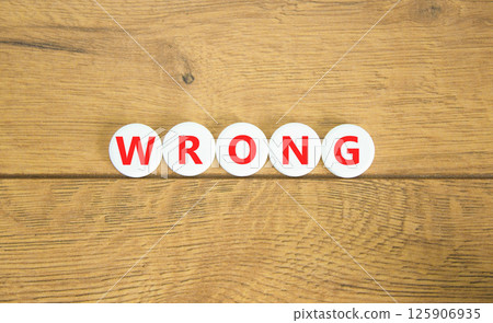 Wrong symbol. Concept word Wrong on beautiful white pills circles. Beautiful wooden table wooden background. Business lifestyle wrong concept. Copy space. 125906935