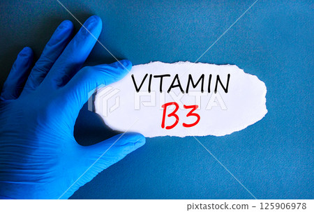 Vitamin B3 niacin symbol. Concept words Vitamin B3 on beautiful white paper. Doctor's hand in blue medical glove. Beautiful blue background. Medical healthy lifestyle Vitamin B3 niacin concept. 125906978
