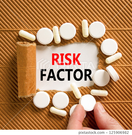 Risk factor symbol. Concept words Risk factor on beautiful white paper. White pills tablets. Doctor's hand. Beautiful brown background. Medical healthy lifestyle risk factor concept. 125906982