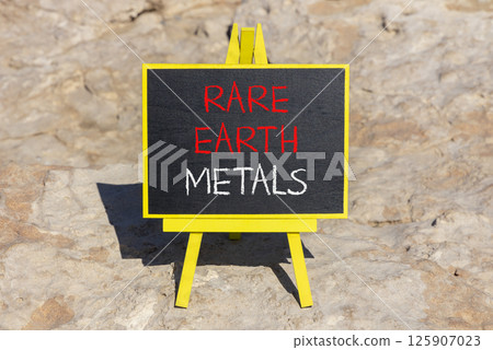 Rare earth metals symbol. Concept words Rare earth metals on beautiful blackboard. Beautiful brown stone beach background. Business and rare earth metals concept. Copy space. 125907023