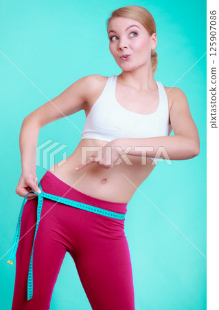 Fitness woman fit girl with measure tape measuring her loins Fitness woman fit girl with measure tape measuring her loins 125907086