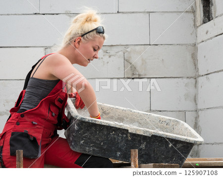 Female builder working build new house Female builder working build new house 125907108