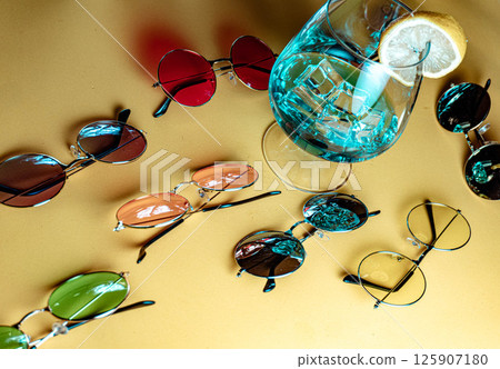 Sunglasses next to tropical cocktail Sunglasses next to tropical cocktail 125907180