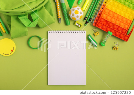 Mockup from notebook with school stationery supplies on green background. Top view. Copy space Mockup from notebook with school stationery supplies on green background. Top view. Copy space 125907220