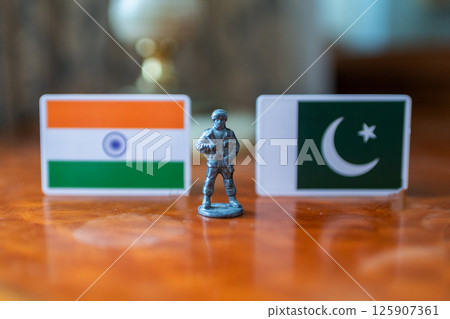 A tin soldier on the background of the flags of India and Pakistan. India Pakistan military conflict A tin soldier on the background of the flags of India and Pakistan. India Pakistan military conflict 125907361