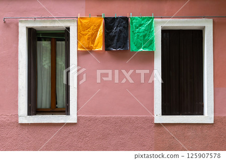Colorful Plastic Bags Hanging on Pink Wall 125907578