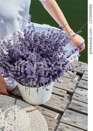 Lavender in a bucket on the pier with the girls. River background. 125908066