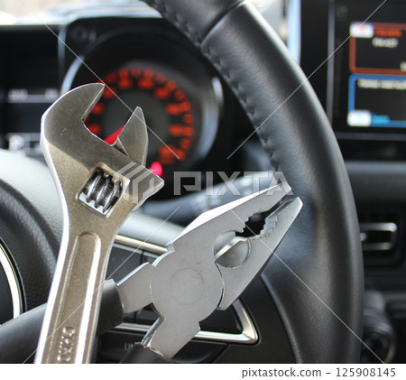 Car Service Concept Image. Adjustable Spanner And Steel Pliers In Front Of Steering Wheel Inside Car 125908145