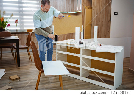 Building a modern furniture piece in a cozy living room setting Building a modern furniture piece in a cozy living room setting 125908151