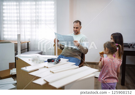 Father and daughters enjoy a DIY project at home on a weekend Father and daughters enjoy a DIY project at home on a weekend 125908152