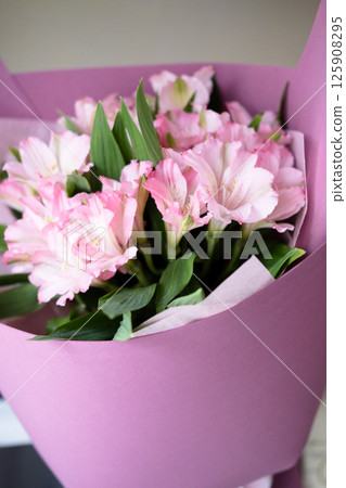 delicate bouquet with pink alstroemerias in wrapping, close-up 125908295